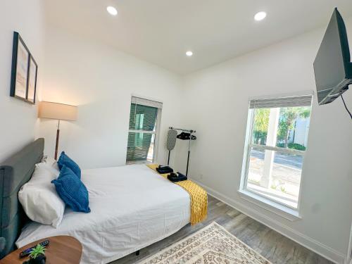 a white bedroom with a bed and a window at 30-A Inn & Suites in Santa Rosa Beach