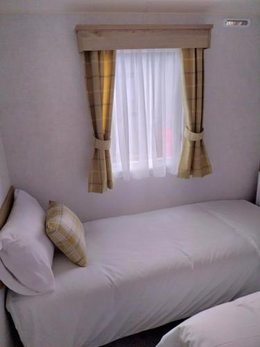 a bed in a bedroom with a window at Luxury 6 berth Caravan Lytham in Preston