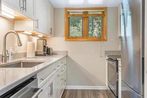a kitchen with white cabinets and a wooden window at On Gore Creek, Pet Friendly, Steps from Free Bus Stop & Great Value in Vail