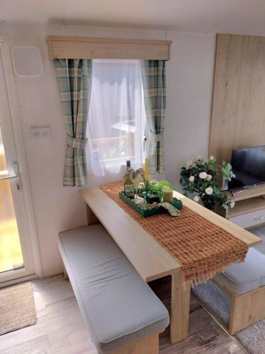 a small kitchen with a wooden table and a table and chair at Luxury 6 berth Caravan Lytham in Preston