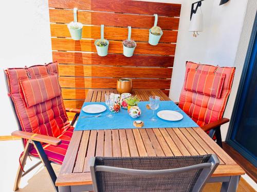 a wooden table with two chairs and a table with glasses at Private apartment with stunning ocean views and sunset. in Taurito