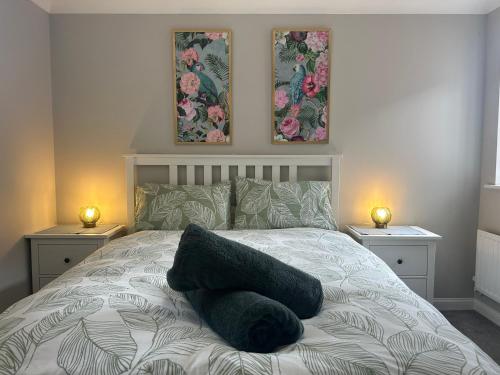 a bedroom with a bed with two lamps and two pictures at City Retreat 3 Bed House with King, Double and Single in Southampton