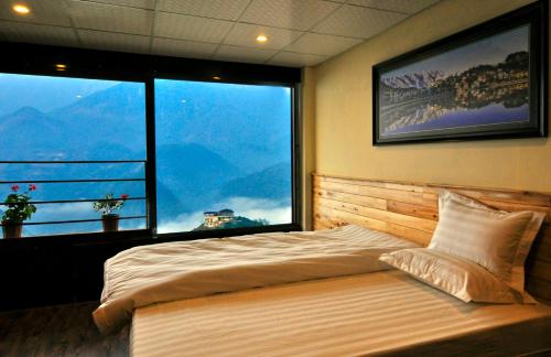 a bedroom with a large bed and two large windows at Fansipan Terrace Cafe and Homestay in Sa Pa