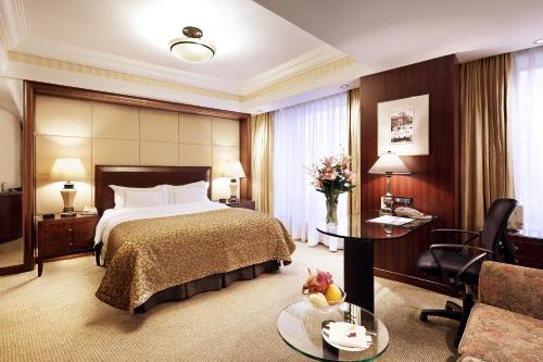 a hotel room with a bed and a living room at Lakeview Xuanwu Hotel in Nanjing