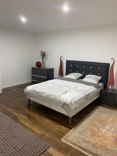 une chambre avec un lit avec une tête de lit noire dans l'établissement Appartement Cordier, à Saint-Amand-Montrond