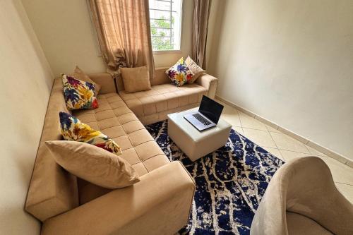a living room with a couch and a laptop on a table at Séjour confortable, Plage Skhirat in Skhirat