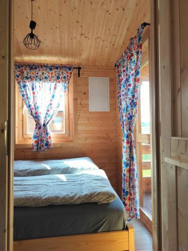 ein Schlafzimmer mit einem Bett in einer Holzhütte in der Unterkunft ENOdomki in Kwilcz