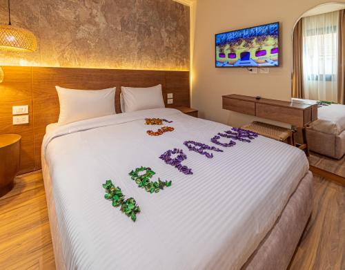 a hotel room with a bed with purple flowers on it at Le Pacha BoutiQue Hotel in Cairo