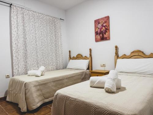 a room with two beds with white sheets at Mirador de Despeñaperros in Santa Elena