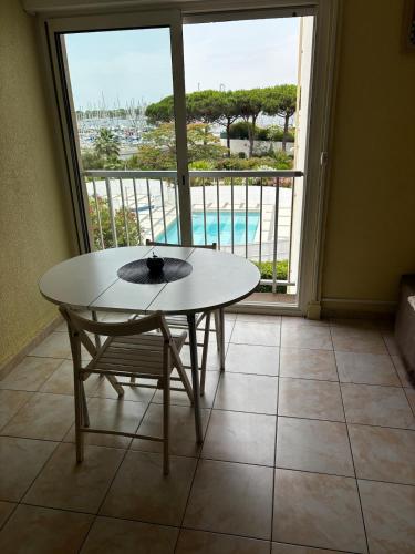 une table et une chaise dans une pièce avec une fenêtre dans l'établissement Studio Pharo Cap D'Agde, au Cap d'Agde