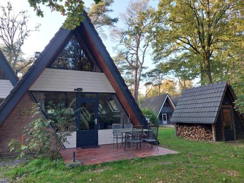 a house with a gambrel roof with a patio at Chalet in Tyrol near Ski Slope in Stramproy