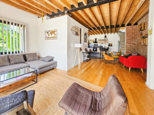 un salon avec un canapé et une table dans l'établissement Loft Campagnard, Jardin, Terrasse, à Saint-Augustin