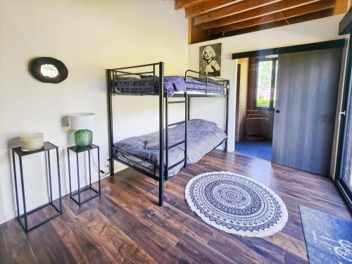 a room with two bunk beds and a wooden floor at Loft Campagnard, Jardin, Terrasse in Saint-Augustin