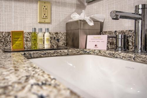 a bathroom counter with a bath tub in a room at DoubleTree by Hilton Dallas-Farmers Branch in Farmers Branch