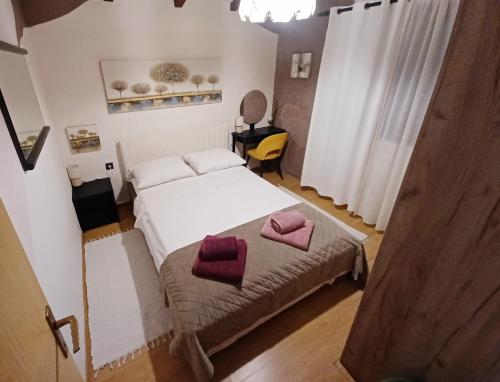 a bedroom with a bed with two pillows on it at Apartman Marija in Barban