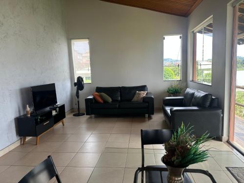a living room with a couch and a tv at Casa no Condomínio Naútico Porto da Pedra em Ijaci in Macaia