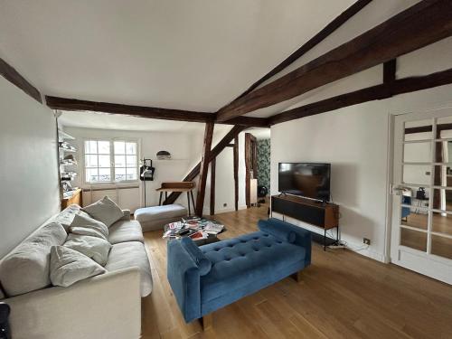 un salon avec un canapé et une télévision dans l'établissement Luxurious apartment Palais de l'Élysée, à Paris