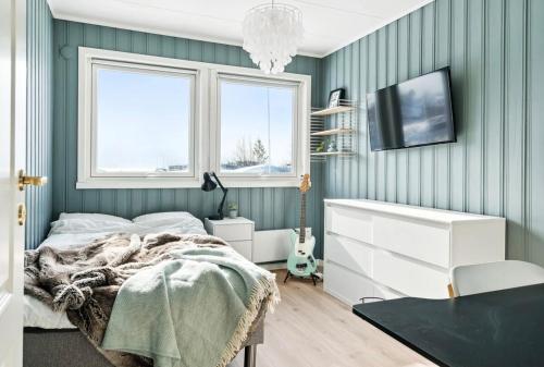 een slaapkamer met groene muren en een bed en een tv bij Hus i Lofoten in Kabelvåg