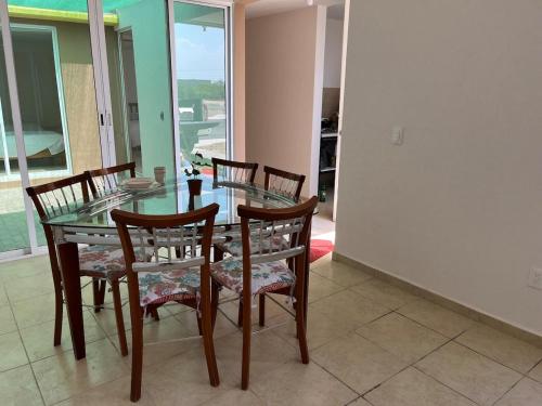 a dining room with a glass table and chairs at Casa Jardines del Mirador in San Juan del Río