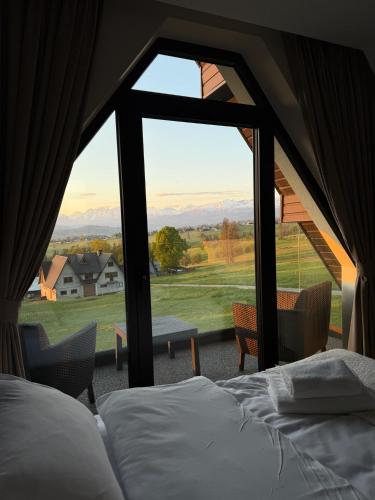 a bedroom with a bed and a large window at Osada Jager in Bańska Wyżna