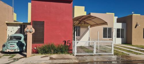 a red building with a car parked outside of it at Casa Jardines del Mirador in San Juan del Río
