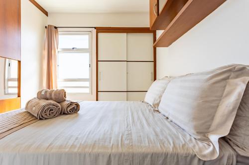 a bedroom with a large bed with towels on it at 4 km da Esplanada com garagem coberta e elevador na Asa Norte in Brasilia