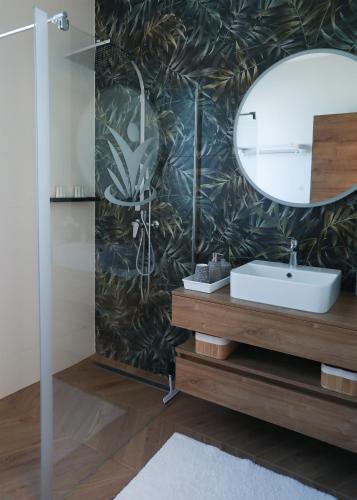 a bathroom with a sink and a mirror at Happy Island Luxury Apartman Sárvár in Sárvár