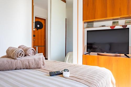 a bedroom with a bed with a flat screen tv at 4 km da Esplanada com garagem coberta e elevador na Asa Norte in Brasilia
