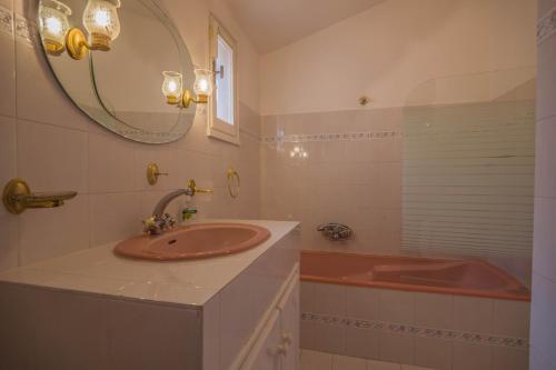 La salle de bains est pourvue d'un lavabo et d'une baignoire rouge. dans l'établissement Villa bellevue sainte maxime un écrin de verdure au cœur du sémaphore piscine XXL, à Sainte-Maxime