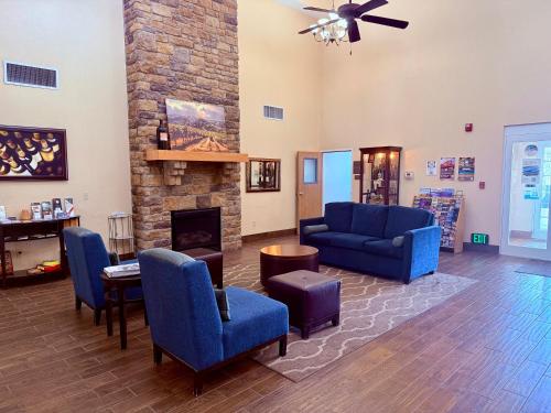 a living room with blue chairs and a fireplace at Comfort Inn & Suites Walla Walla in Walla Walla