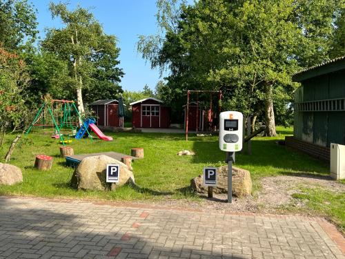 a parking meter in a park with a playground at Haus Hugo Zingst in Zingst