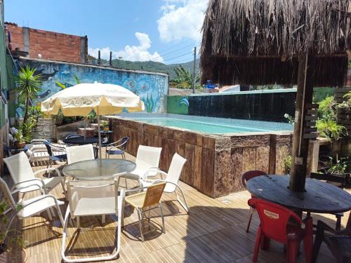 a patio with a table and chairs and a pool at Bonita Ilha Frente Mar Guarujá in Guarujá