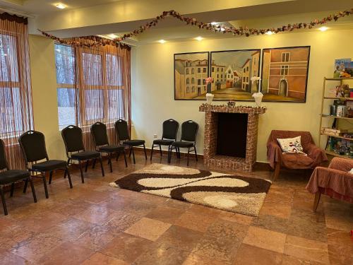 a living room with chairs and a fireplace at Salgó Hotel in Salgótarján