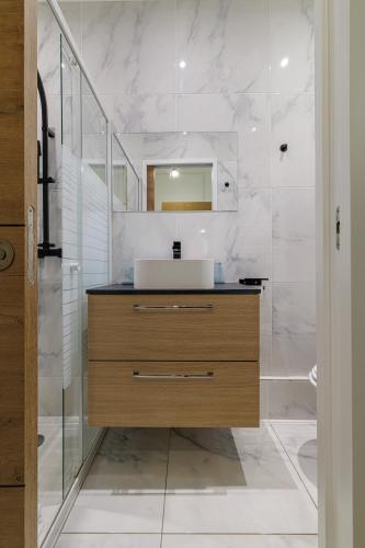 une salle de bain avec un lavabo et un miroir dans l'établissement FOSSAN - Charmant appartement à 5min du centre-ville, à Menton