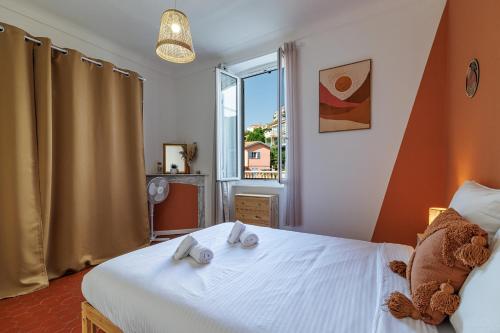 une chambre avec un grand lit blanc avec une fenêtre dans l'établissement FOSSAN - Charmant appartement à 5min du centre-ville, à Menton