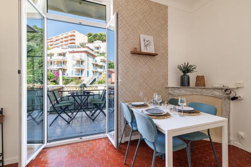 une salle à manger avec une table et des chaises et un balcon dans l'établissement FOSSAN - Charmant appartement à 5min du centre-ville, à Menton