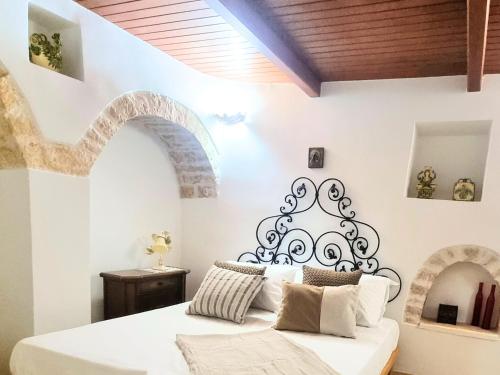 1 dormitorio con cama blanca y cabecero negro en Panoramic Terrace, en Alberobello