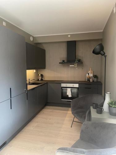 a kitchen with black cabinets and a table in a room at Familiy apartment in Myrkdalen Voss in Vossestrand