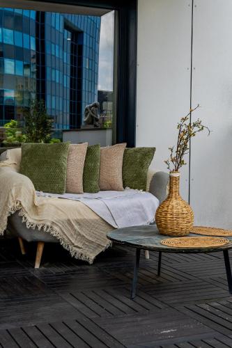 a couch on a patio with a table and a vase at Terra Luxe Residence in Bucharest