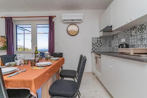 a kitchen with a wooden table with chairs and a table and a counter at Sea view apartment Dominique in Cavtat