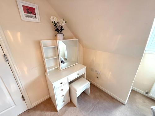 a white dressing table with a mirror and a stool at Torwood Townhouse - SuperFast WiFi, Contractor Friendly with Free Parking in Edinburgh