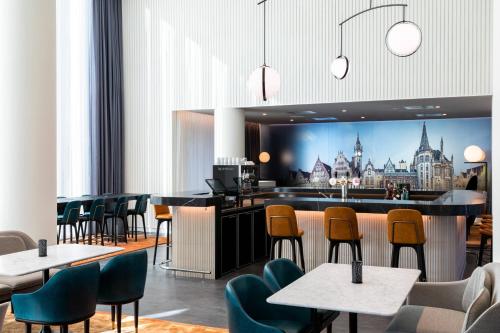 a restaurant with a bar with chairs and tables at Residence Inn by Marriott Ghent in Ghent