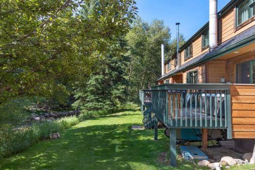 a house with a deck next to a yard at Private Hot Tub Overlooking Gore Creek, Parking for 4, Updated Townhome in Vail