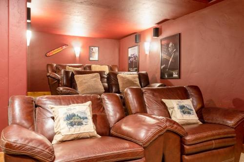 a brown leather couch sitting in a room at Outdoor Private Hot Tub, In Home Movie Theater, Luxurious Creekside Home in Vail