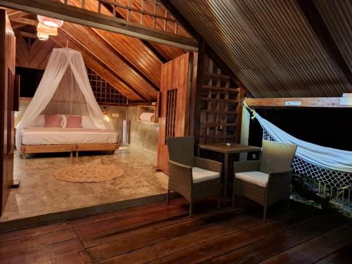a bedroom with a bed and a hammock in a room at Mangle House Cabañas Ladrilleros in Buenaventura