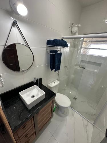 a bathroom with a sink and a toilet and a mirror at Villa Cavaliere in Palhoça