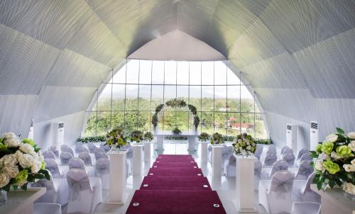 a wedding hall with white chairs and a purple aisle at Novotel Manado Golf Resort & Convention Center in Manado