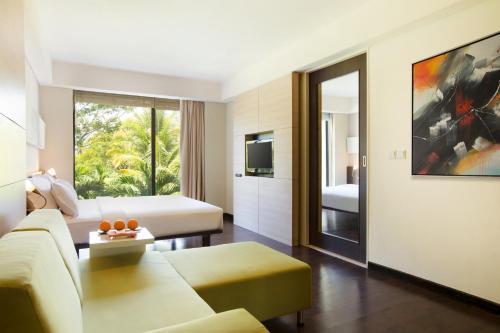 a living room with a couch and a tv at Novotel Manado Golf Resort & Convention Center in Manado