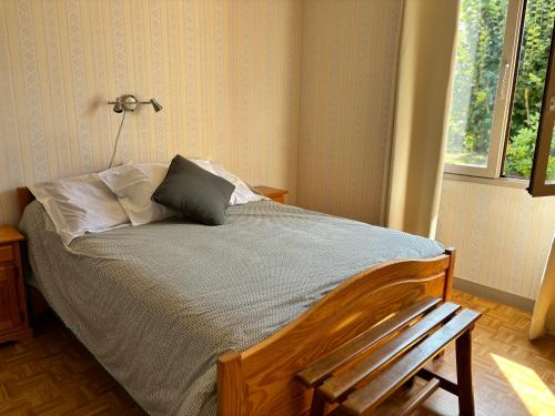 a bedroom with a bed with a chair and a window at Chez Colette, maison agréable in Villebernier