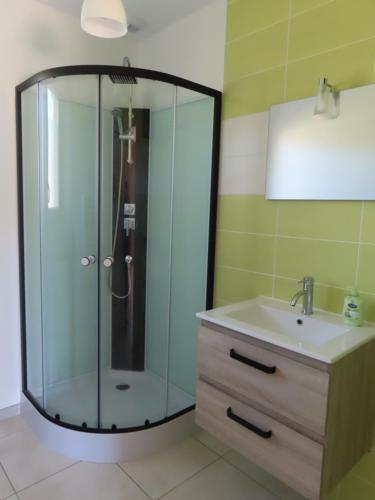 une salle de bain avec une douche en verre et un lavabo dans l'établissement Appartement neuf dans maison individuelle, à Bergerac